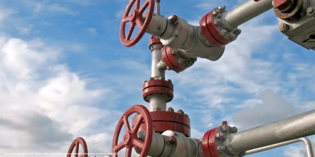 Industrial gas pipeline valves against a blue sky representing the analysis of Petras Katinas on Russian fossil fuel exports.