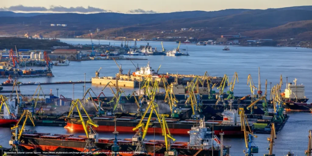 Busy Russian port with multiple cargo ships and cranes, symbolizing Kongsberg violation of Russia sanctions in maritime trade activities.