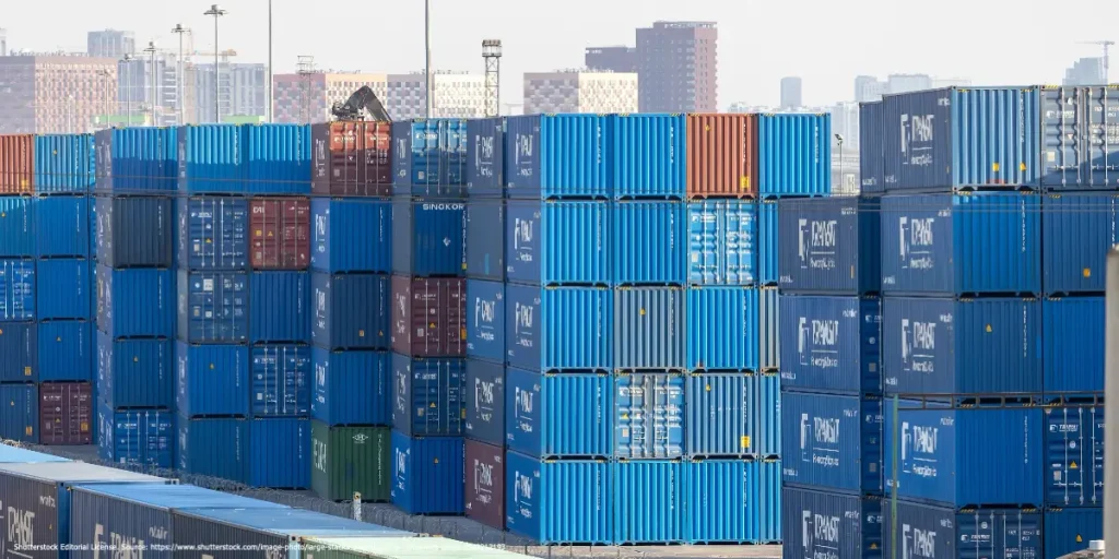 Shipping containers stacked at a busy port, symbolizing trade activities connected to Torbjörn Becker Sanctions Evasion concerns.