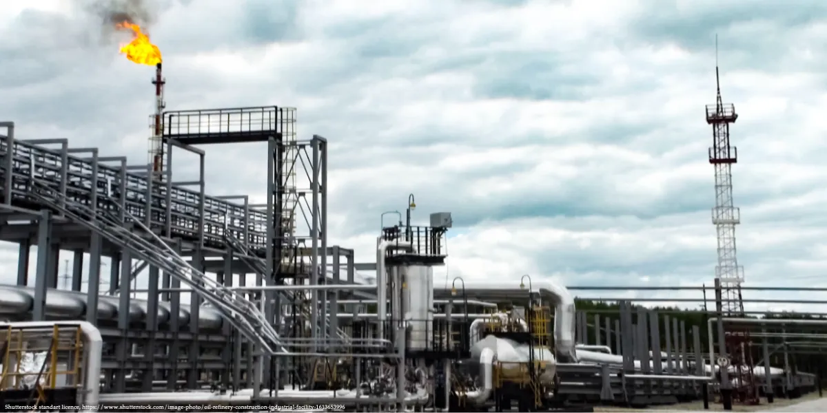 Industrial oil refinery in Russia with gas flare burning, representing the impact of U.S. sanctions on Russia’s oil industry.