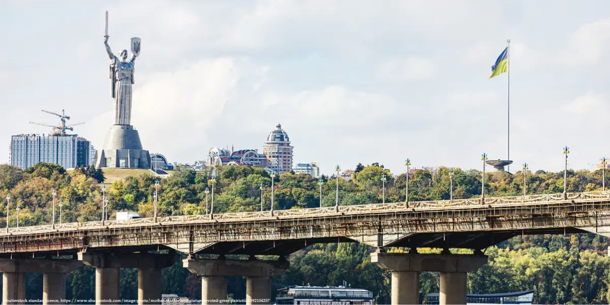 Kyiv skyline, Motherland Monument, bridge, and Ukrainian flag representing the article by Henrik Wachtmeister: Ukraine Can Deliver Decisive Blow.